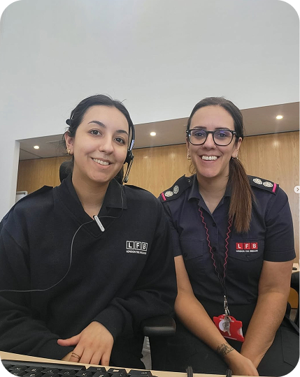 Two colleagues sit together at a reception desk.