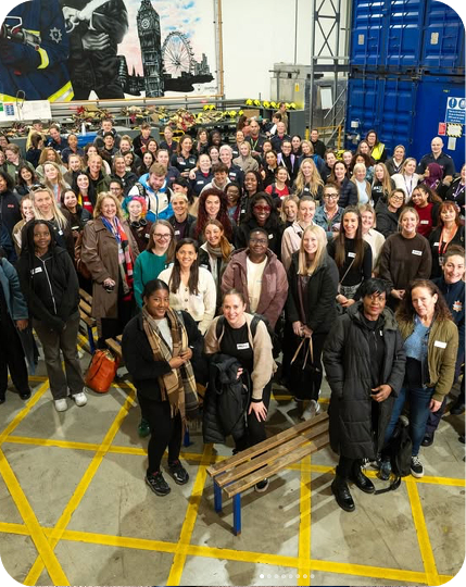 Large group gathered in warehouse for community networking event.
